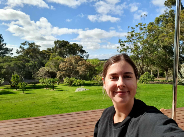 Image of Jessica with grass and trees in the background