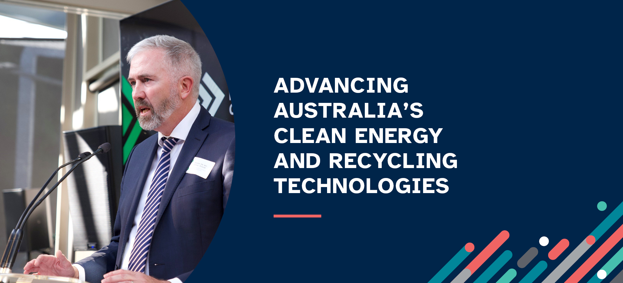 Image of Assistant Minister for Education, Senator the Hon Anthony Chisholm, speaking at a podium dressed in a business suit.  Slogan reads Advancing Australia's clean energy and recycling technologies.