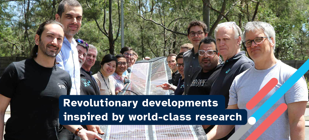 15 people holding a printed solar panel with the words "Revolutionary developments inspired by world-class research"
