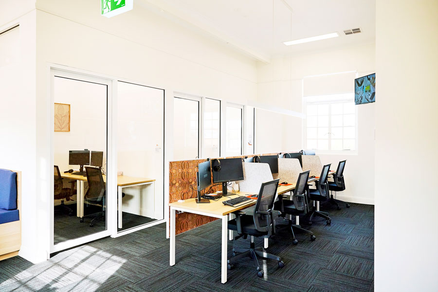 A room with desks, chairs and computers.