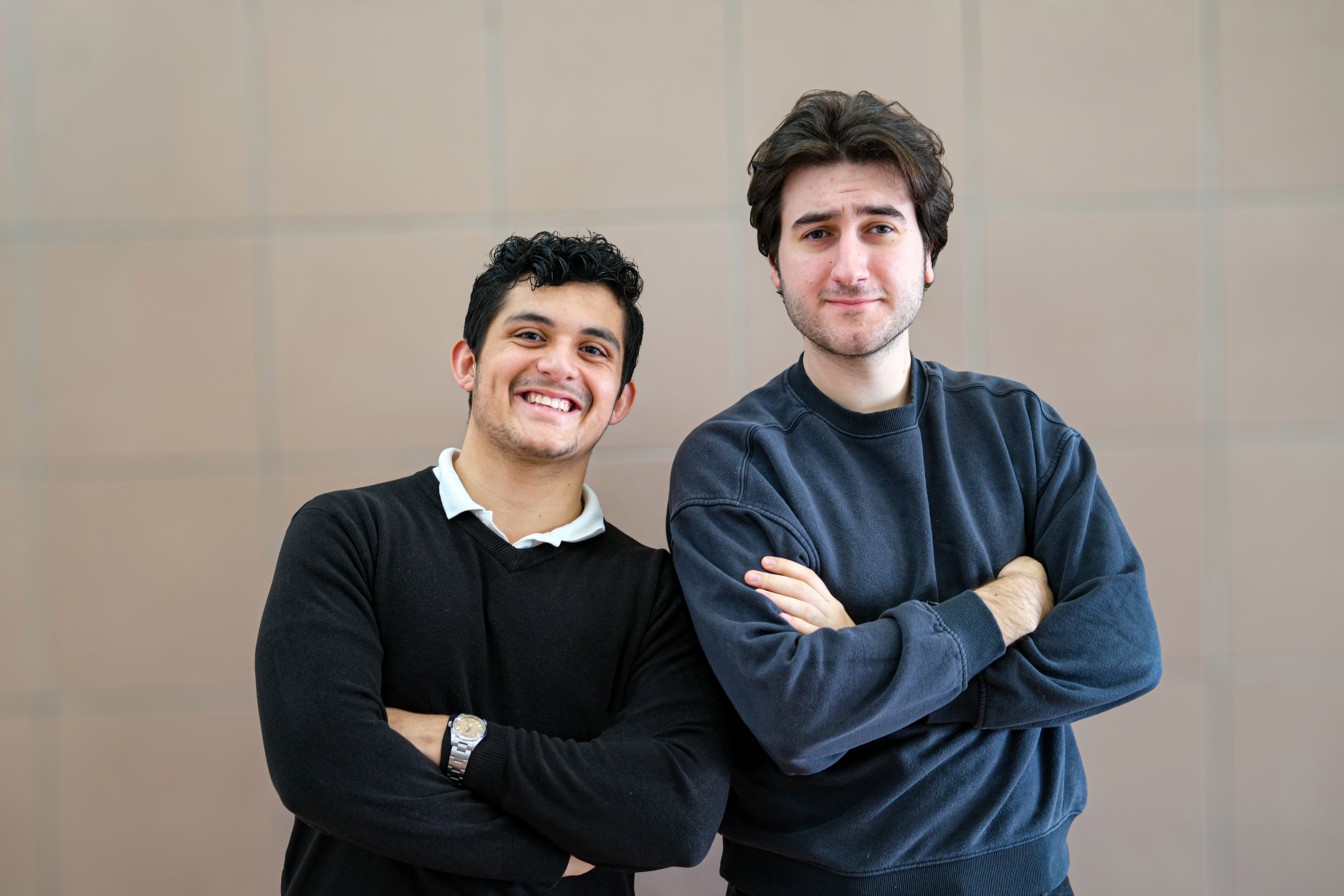 Anis and Leon standing with arms crossed towards camera