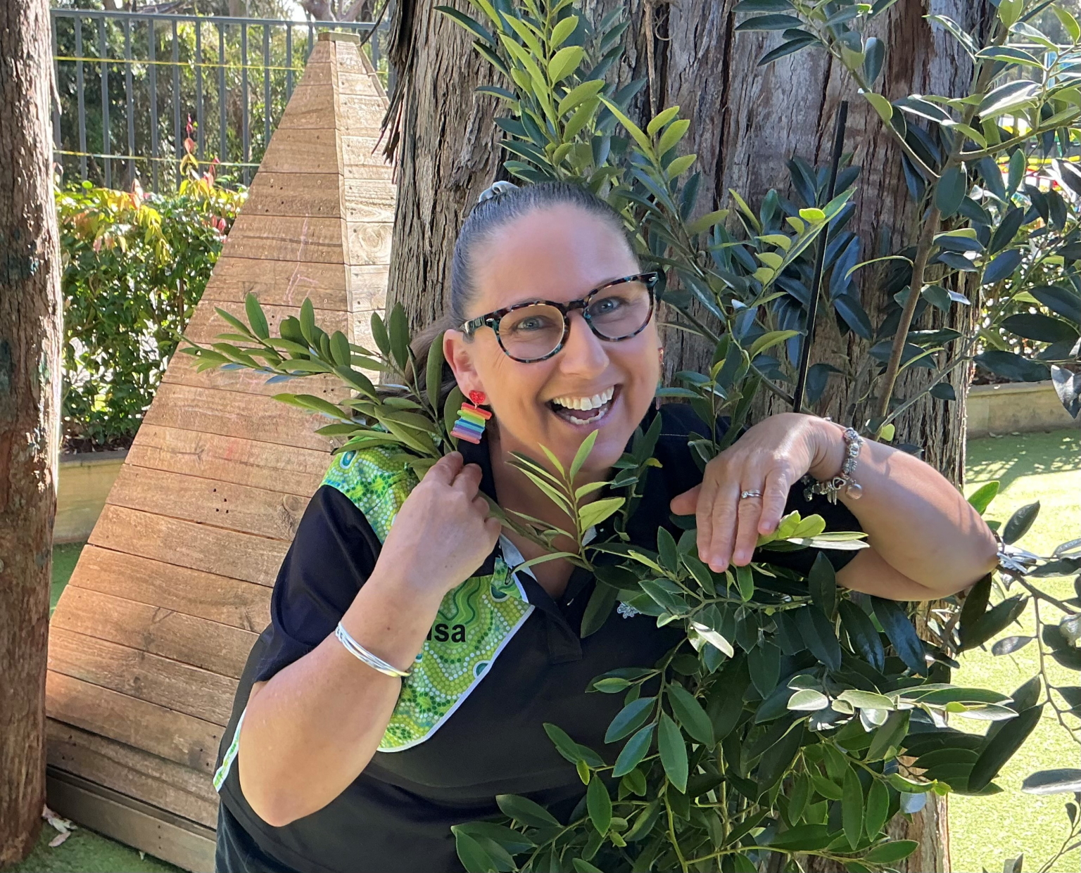 Lisa Brennan smiling behind some plants 