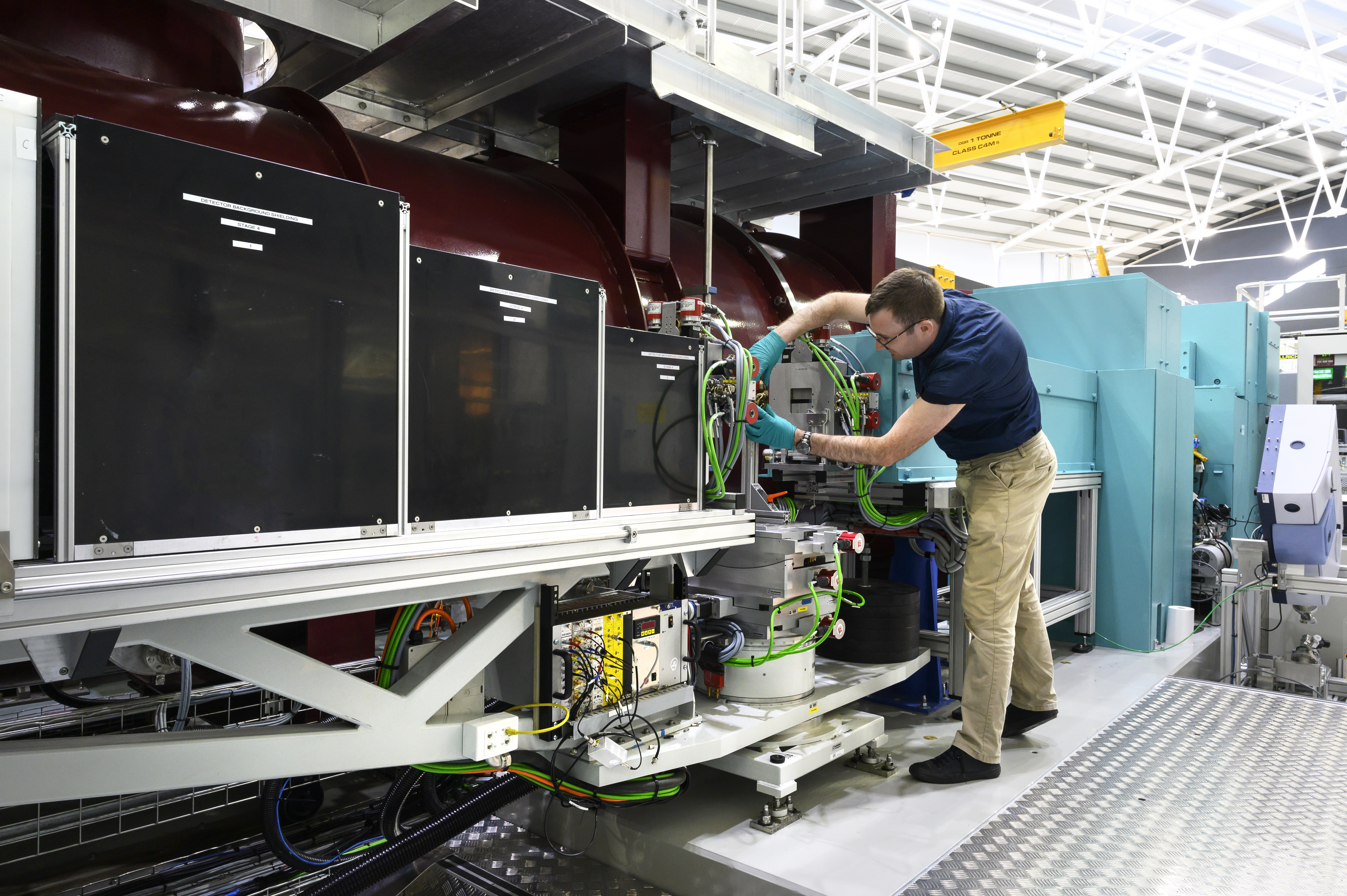 The Spatz neutron reflectometer at the Australian Centre for Neutron Scattering with instrument scientist Anton Le Brun adjusting a sample for measurement.