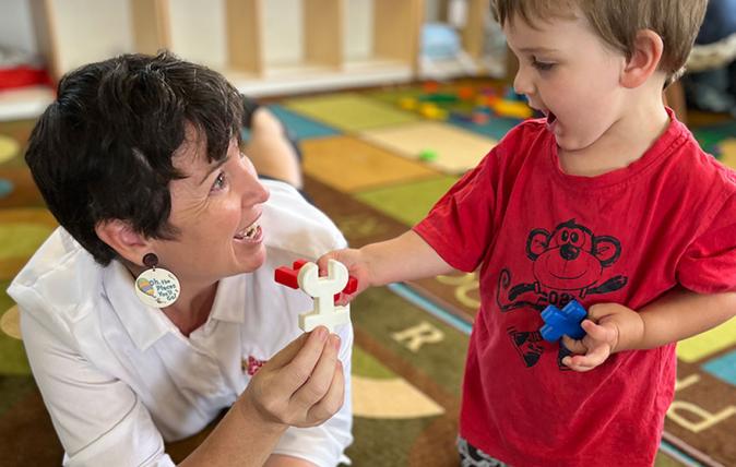 Child care worker playing with child indoors