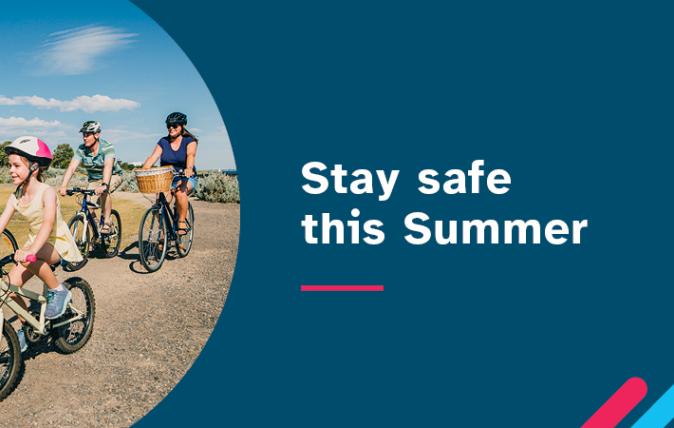 Stay safe this summer. In the background, there are four people riding bicycles together: a man, a woman and two girls.
