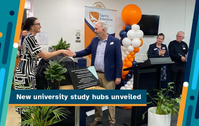 New university study hubs unveiled - Two people shaking hands, smiling and standing in front of a university banner and behind the placard detailing the opening of the Regional University Study Hub being opened.